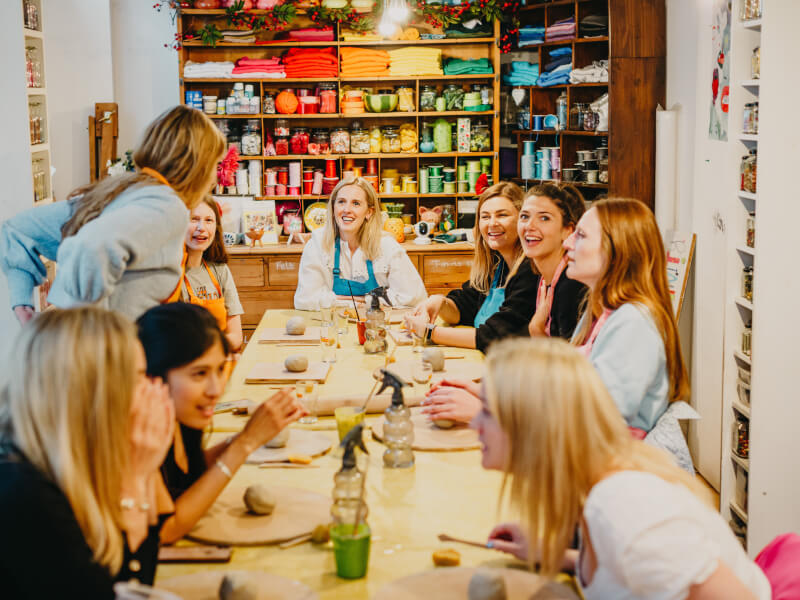 Group of women sitting around the table at a pottery class